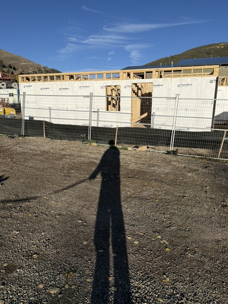 Framed walls at the build site under a blue sky