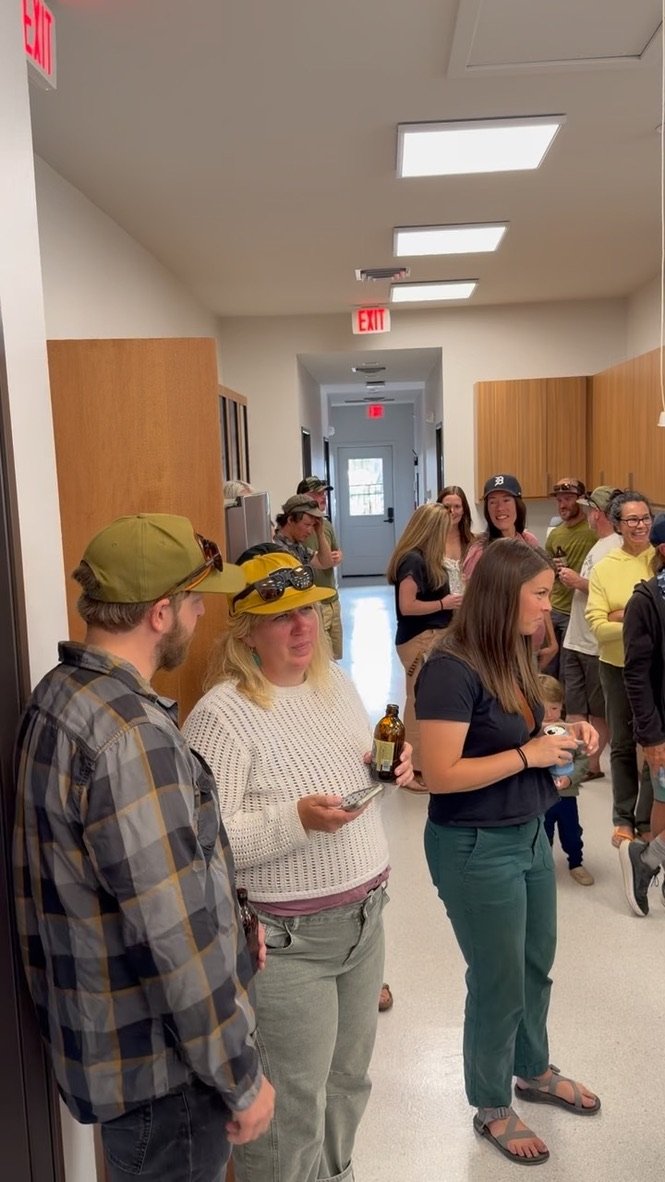 Guests talking and holding drinks in the hallway during the open house