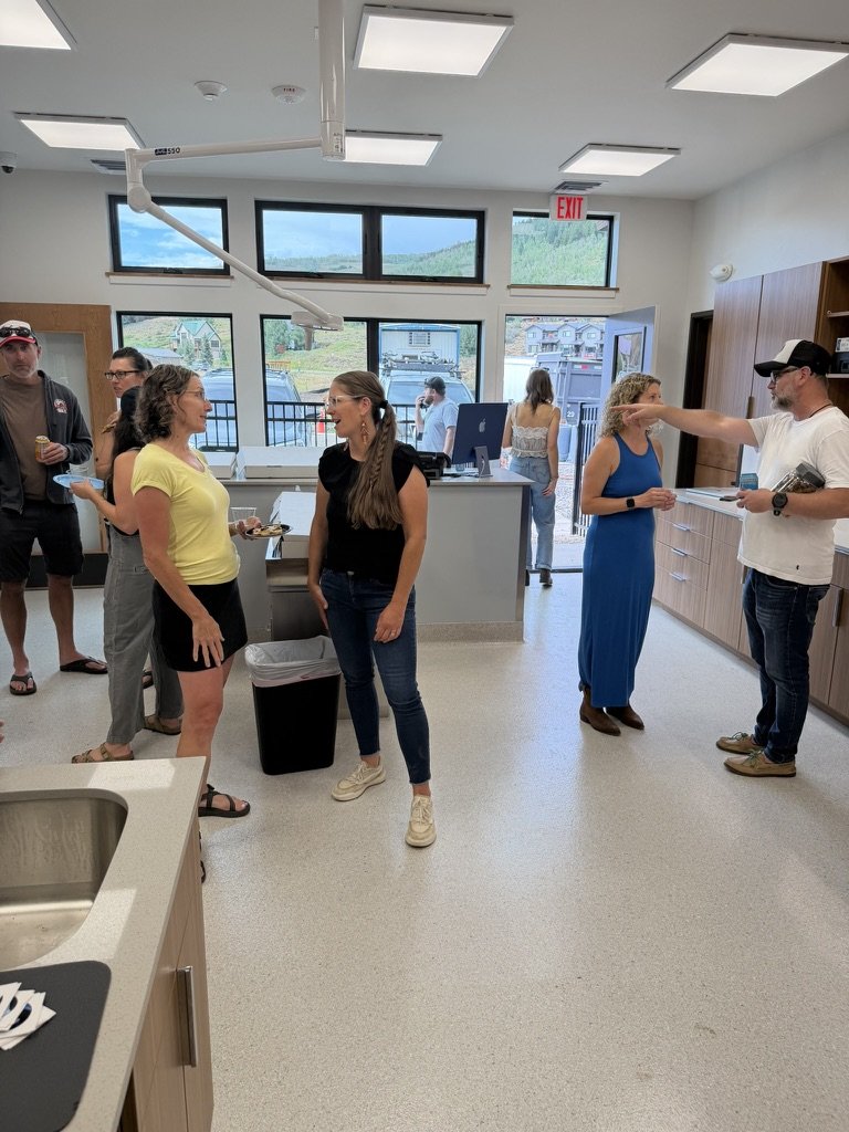 Guests gathered and talking near the front desk during the open house