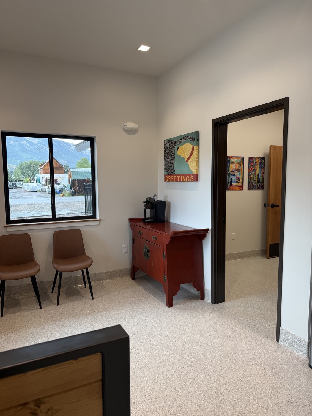 The finished waiting area with leather chairs and a window onto the mountains