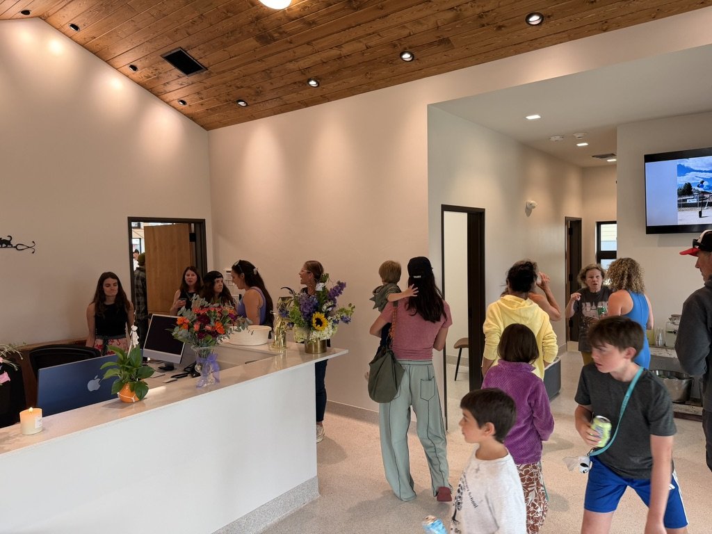 Guests browsing the reception area beside the opening-day flowers