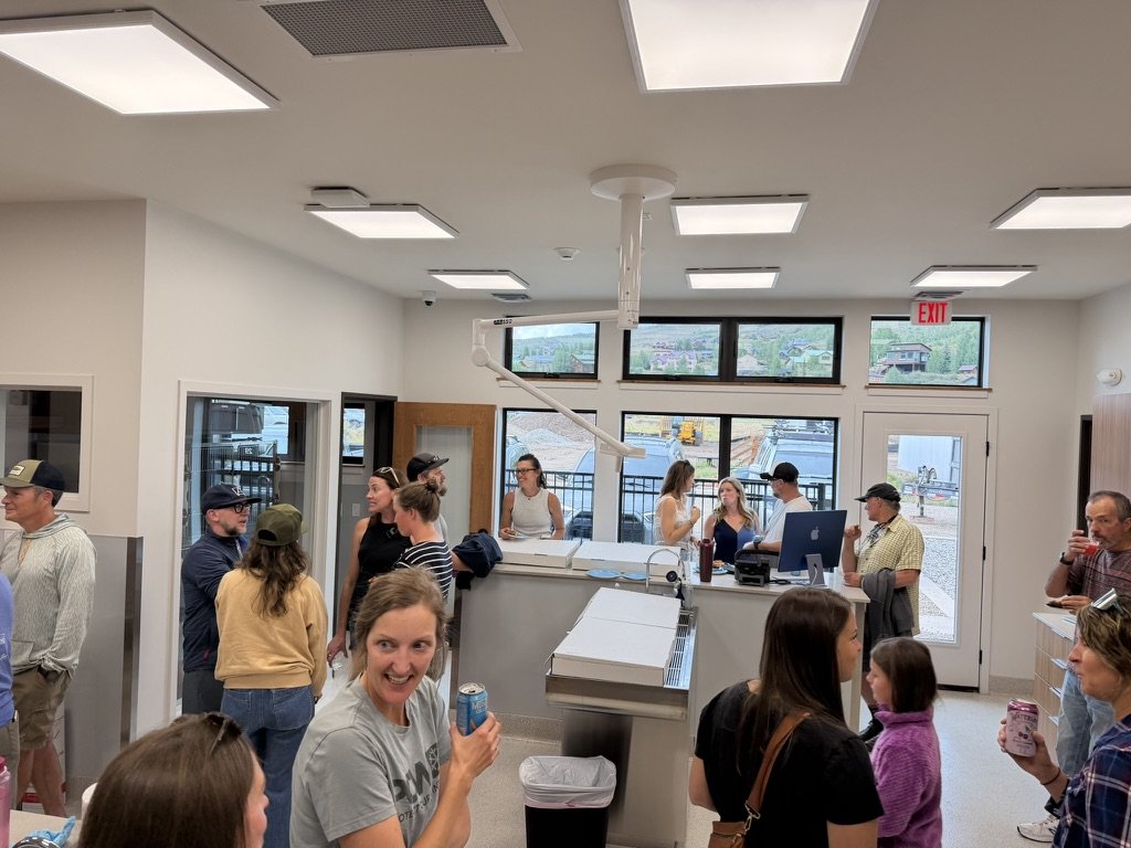 Guests filling the treatment area, talking in groups with drinks in hand