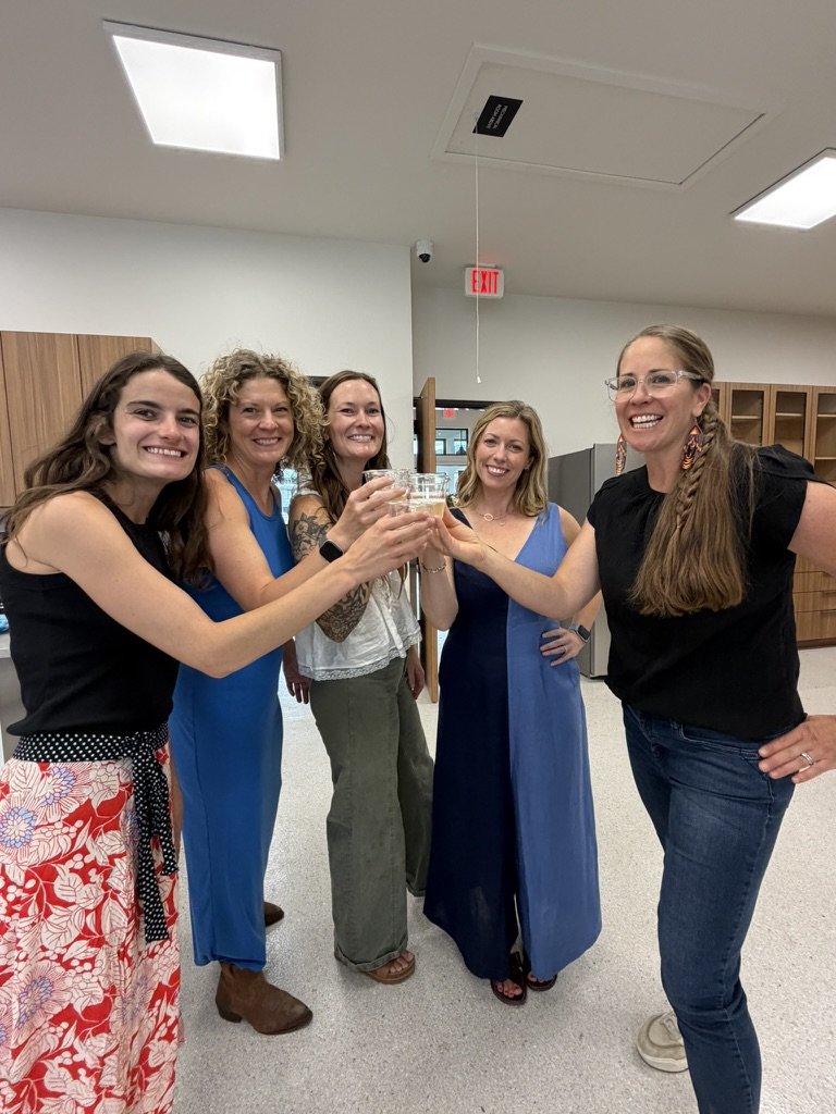 Five of the team raising their glasses in a toast on opening day