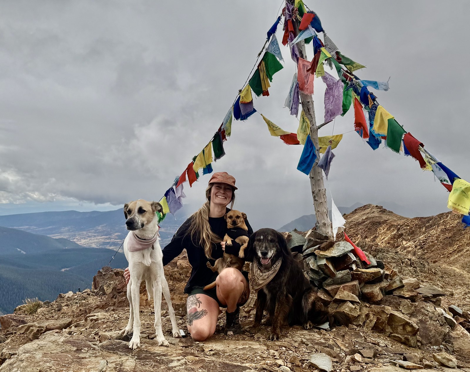 Ellen Teague, Certified Veterinary Technician at Cement Creek Veterinary Hospital, on a mountain summit with her three dogs